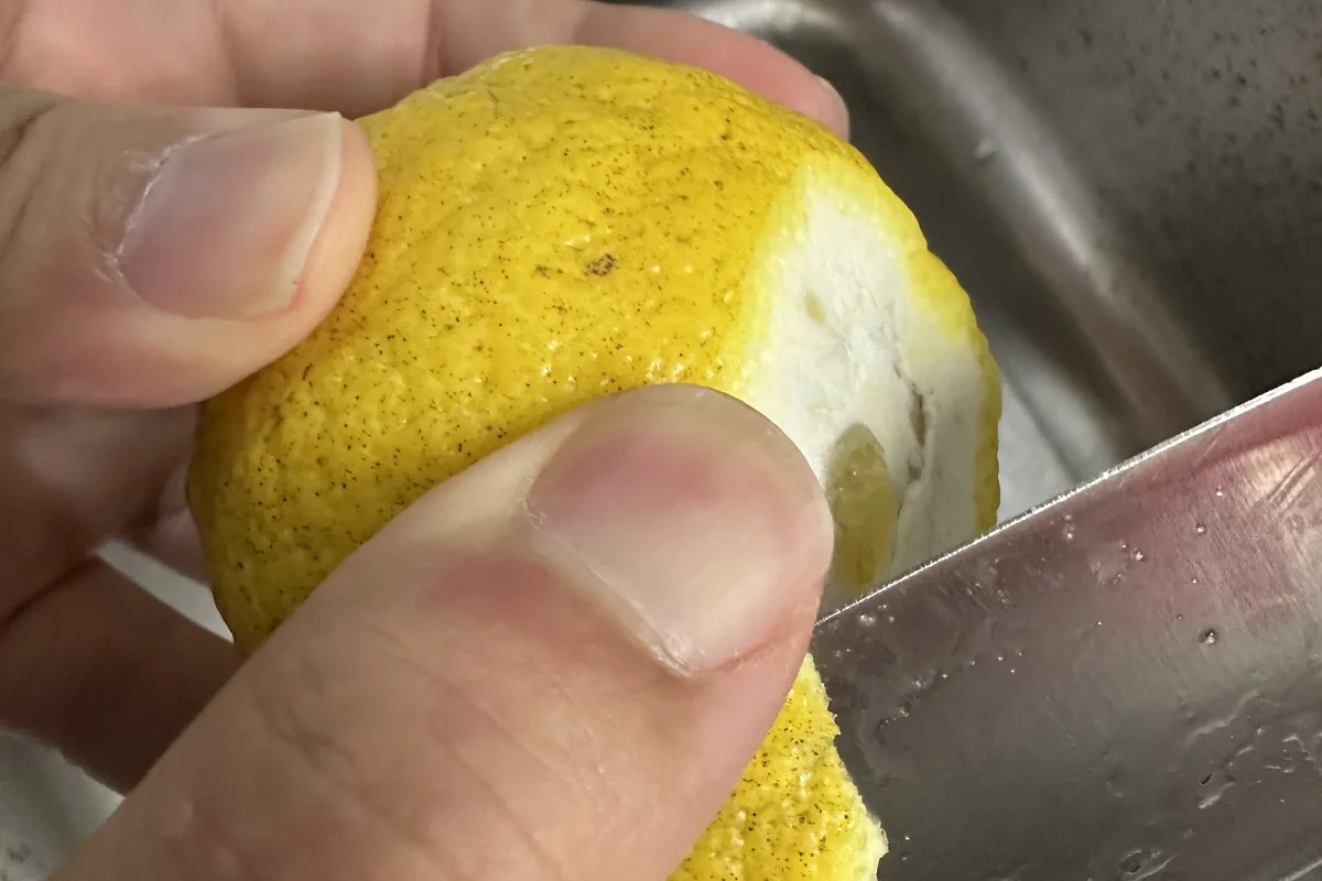 ツルツル皮のせとかを薄切りにしている手元のクローズアップ