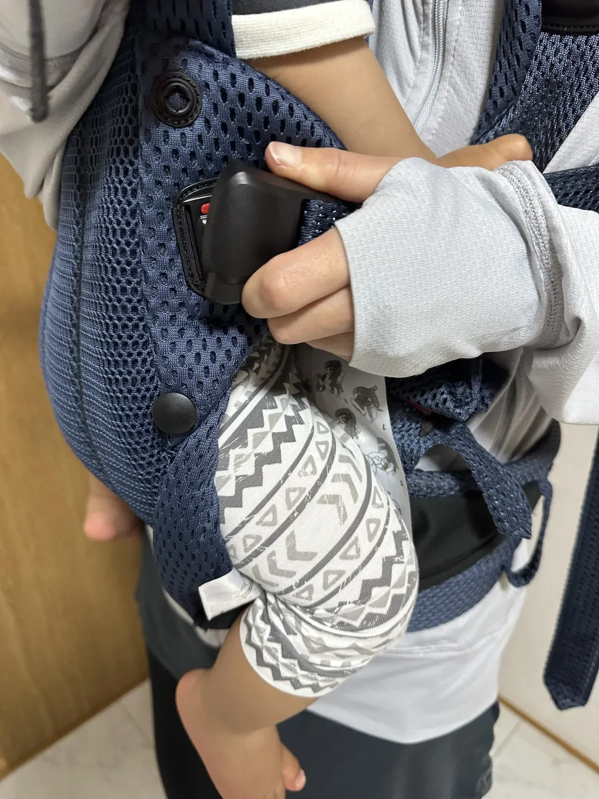 嫁157cmがベビービョルン HARMONY のマグネットバックルを片手で装着しているシーン、着脱の楽さがわかる手元